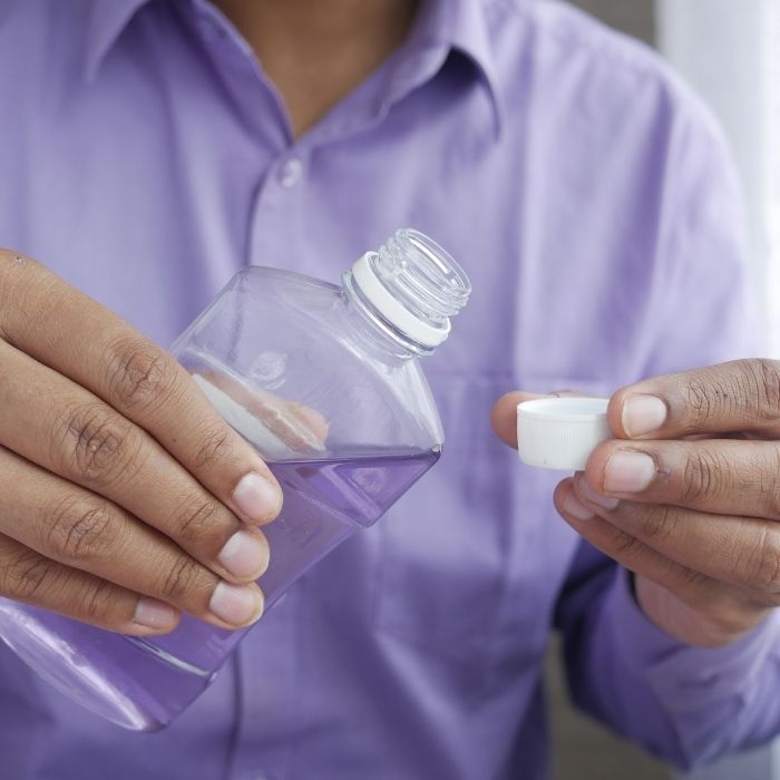 A man pouring mouthwash
